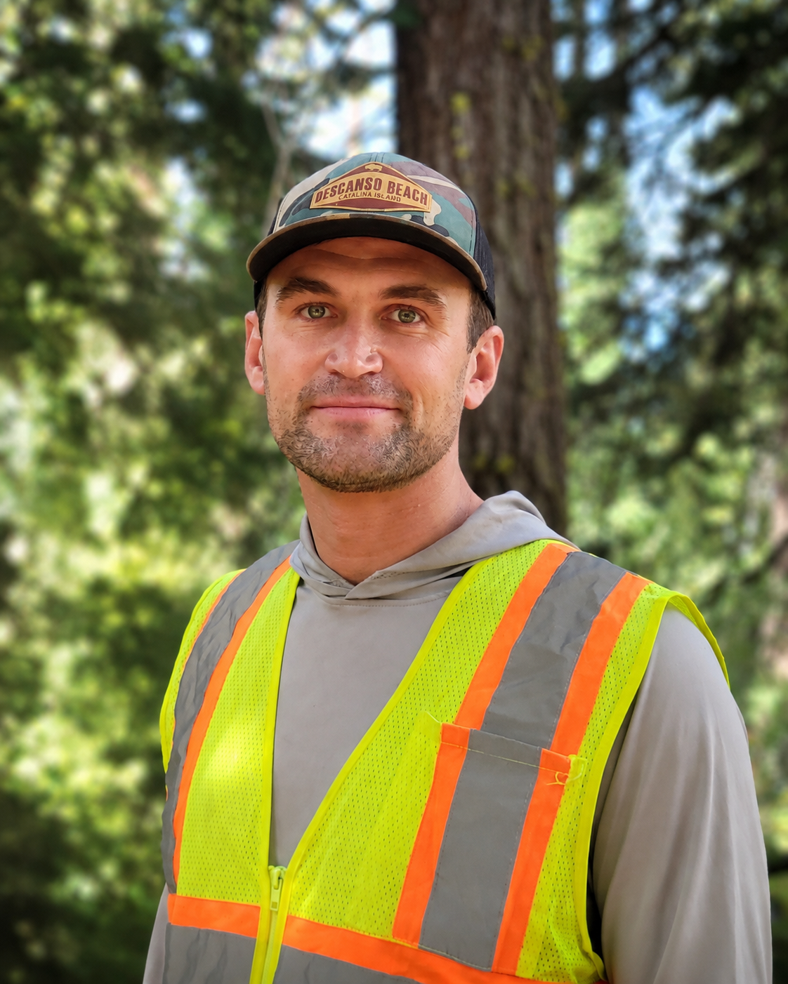 Collin McElroy in field safety attire in a forest setting